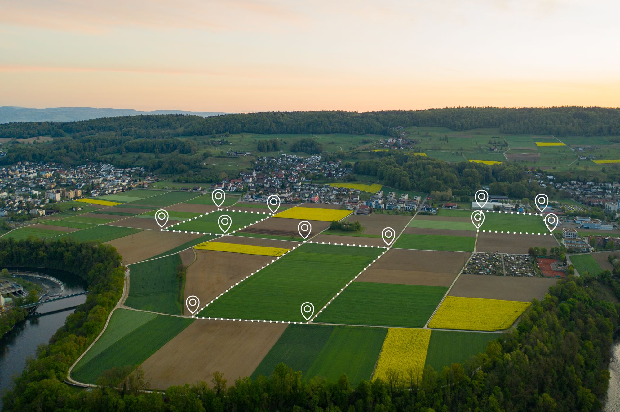 Luchtfoto van landbouwpercelen bij een dorp, met gemarkeerde perceelgrenzen